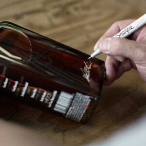 Image: Bottle of Texas bourbon being signed by Master Distiller Donnis Todd