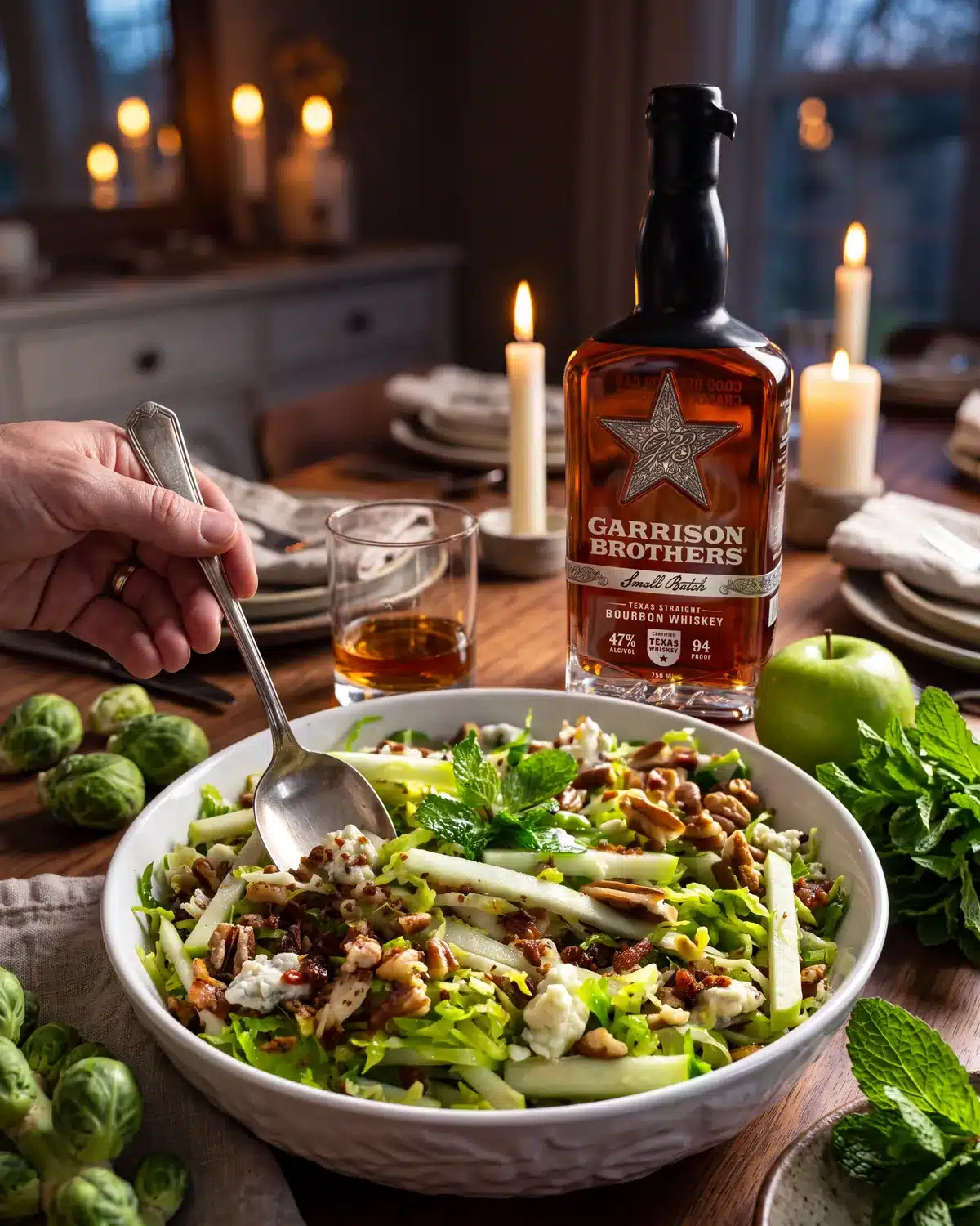 Mint Julep Apple & Brussels Sprout Salad on a dining table with a bottle of Garrison Brothers Small Batch Bourbon