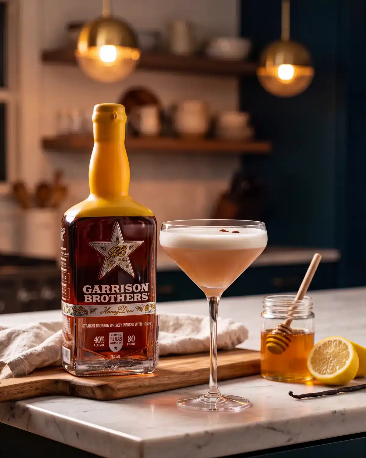 The Humble Bumble bourbon cocktail on a kitchen counter with a bottle of Garrison Brothers HoneyDew Bourbon