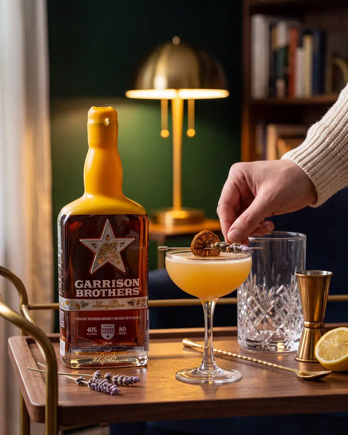Busy Little Bees bourbon cocktail on a home bar cart with a bottle of Garrison Brothers HoneyDew Bourbon
