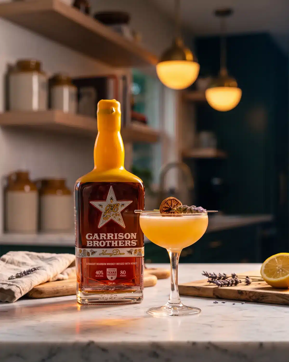 Busy Little Bees bourbon cocktail on a kitchen counter with a bottle of Garrison Brothers HoneyDew Bourbon