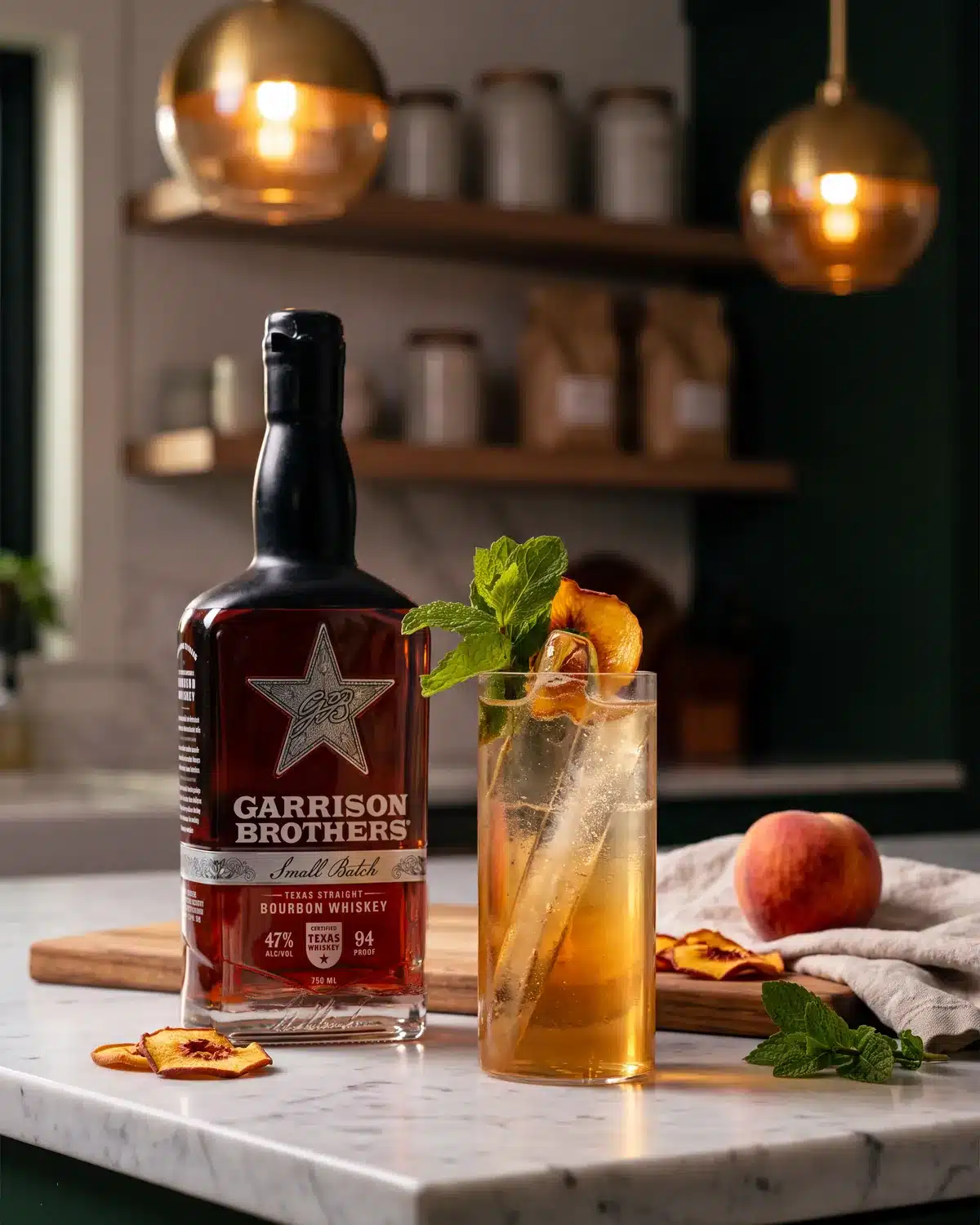 Just Peachy bourbon cocktail on a kitchen counter with a bottle of Garrison Brothers Small Batch Bourbon