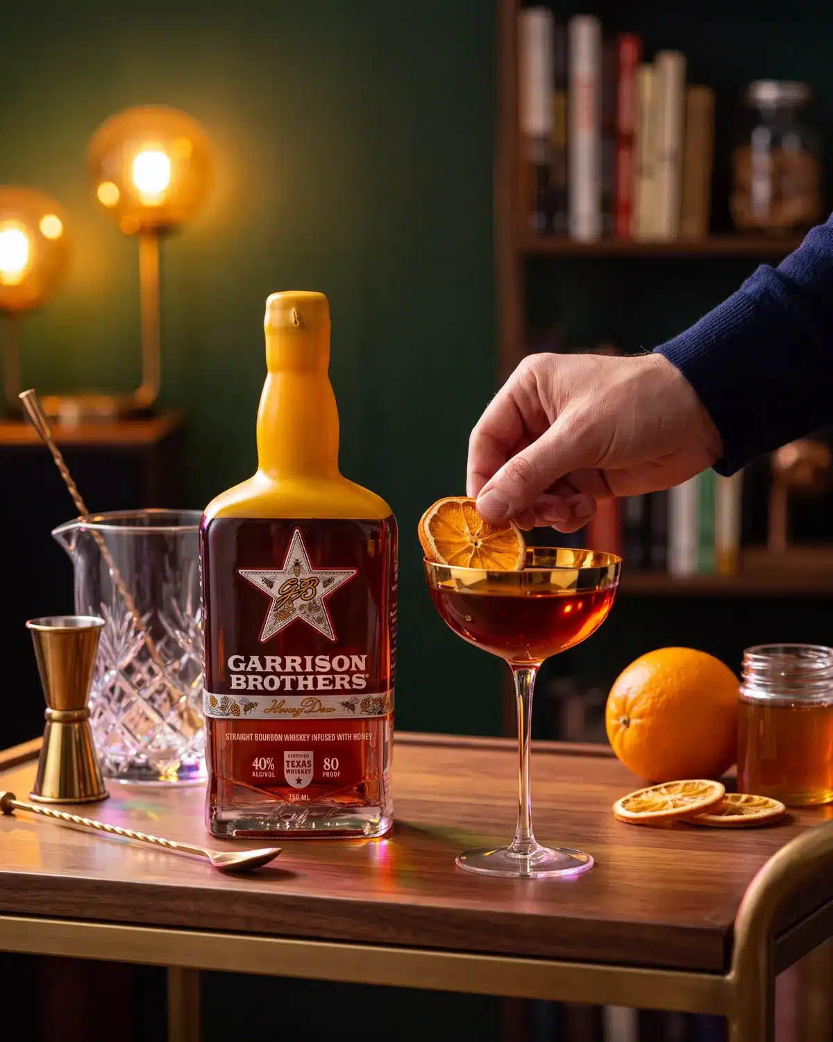 Meant to Bee bourbon cocktail on a home bar cart with a bottle of Garrison Brothers HoneyDew Bourbon