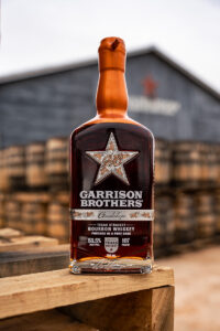 2024 Garrison Brothers Guadalupe Bourbon in front of Dance Hall barrel barn