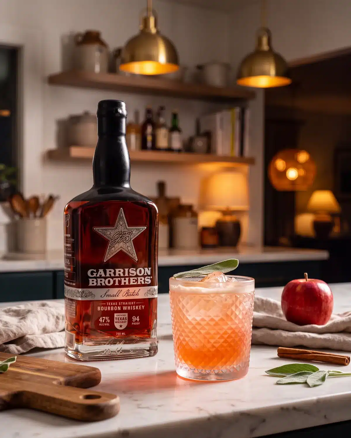 Candy Apple Ragtop bourbon cocktail on a kitchen counter with a bottle of Garrison Brothers Small Batch Bourbon