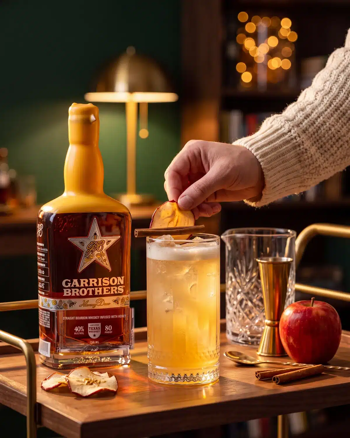 Apple Of My Hye bourbon cocktail on a home bar cart with a bottle of Garrison Brothers HoneyDew Bourbon