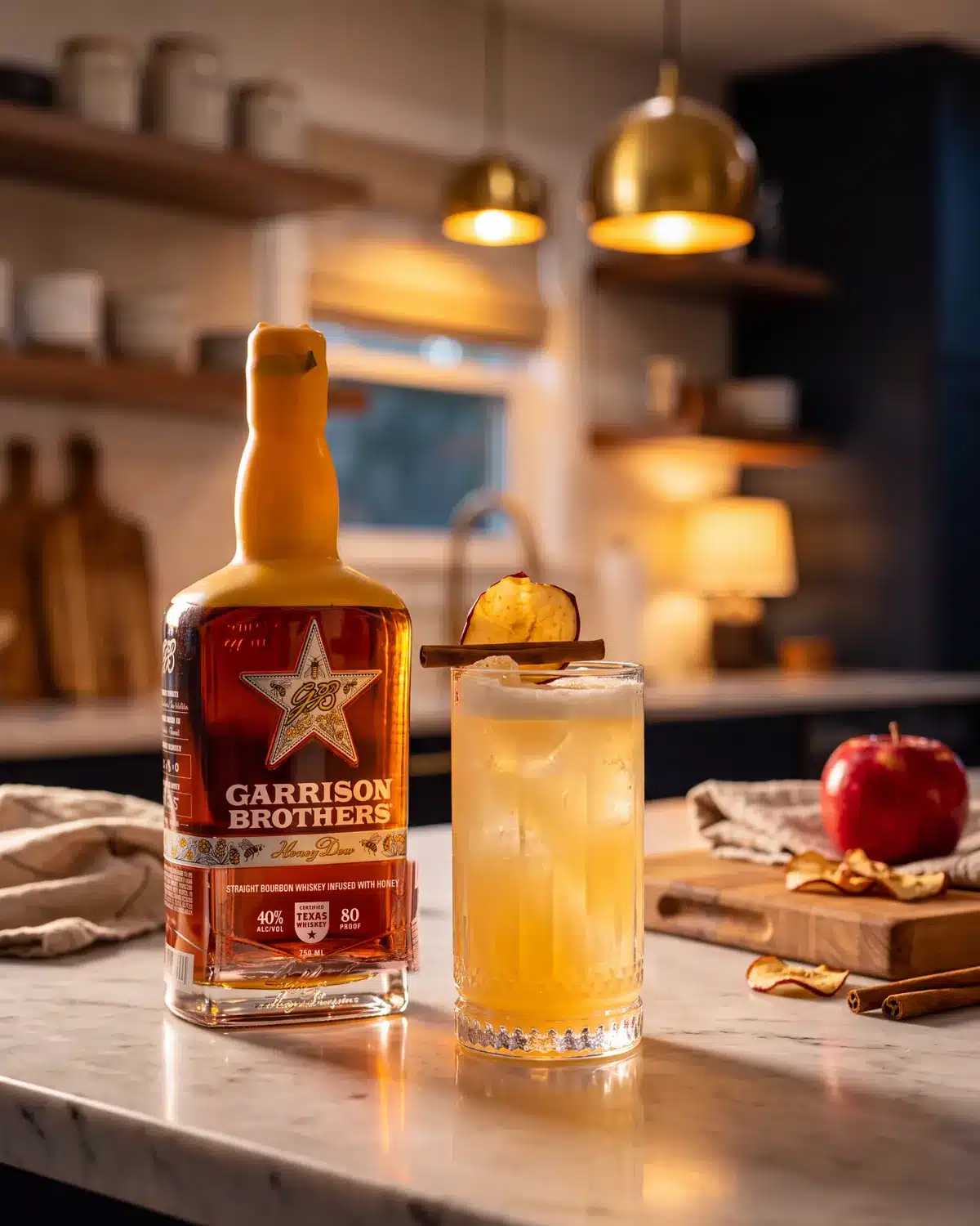 Apple Of My Hye bourbon cocktail on a kitchen counter with a bottle of Garrison Brothers HoneyDew Bourbon