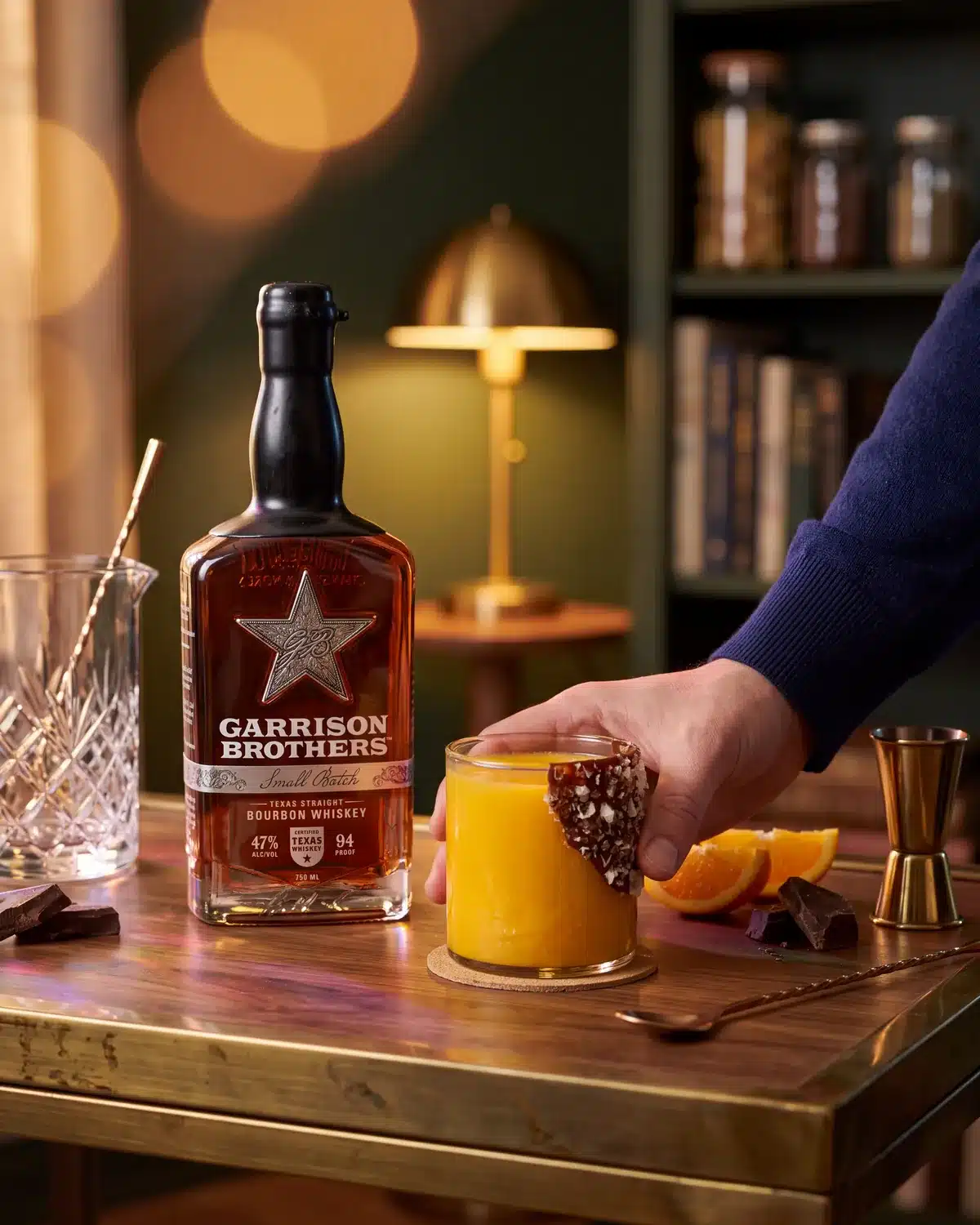 Cosmic Cowboy bourbon cocktail on a home bar cart with a bottle of Garrison Brothers Small Batch Bourbon