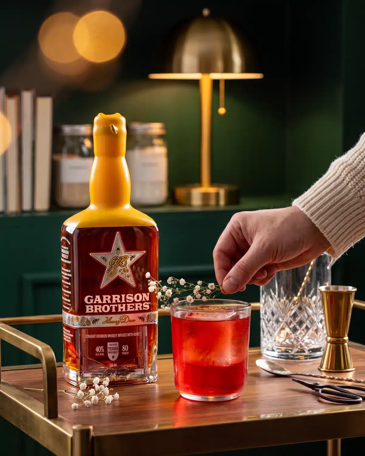 Old Fashioned Sloe-Cookin' bourbon cocktail on a home bar cart with a bottle of Garrison Brothers HoneyDew Bourbon