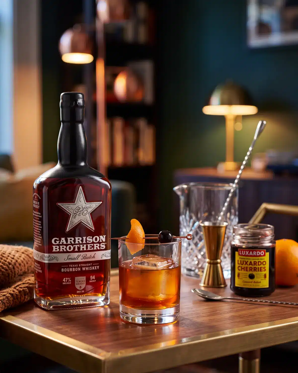 Tapped and Unwrapped bourbon cocktail on a home bar cart with a bottle of Garrison Brothers Small Batch Bourbon