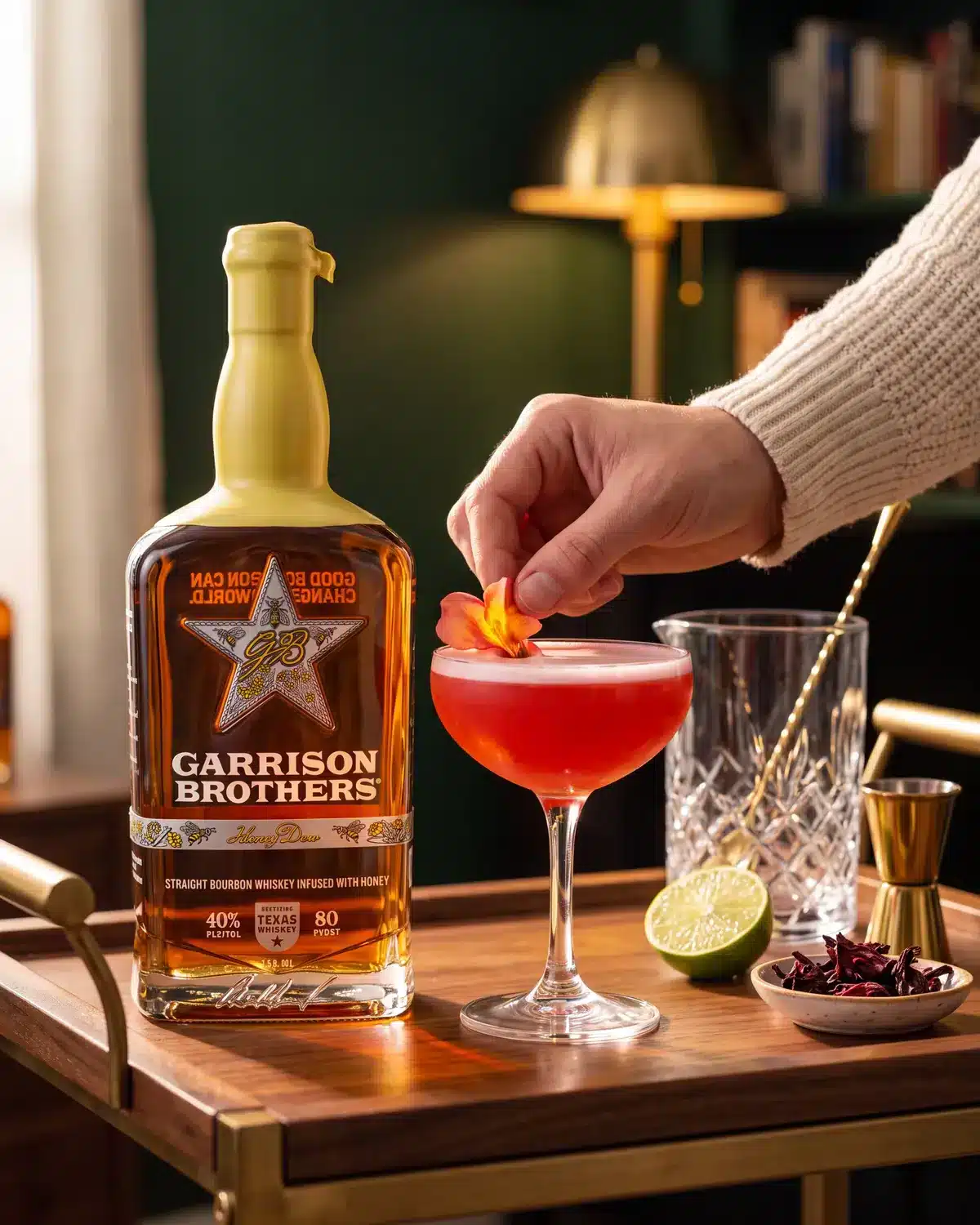Honey Hye-Biscus bourbon cocktail on a home bar cart with a bottle of Garrison Brothers HoneyDew Bourbon