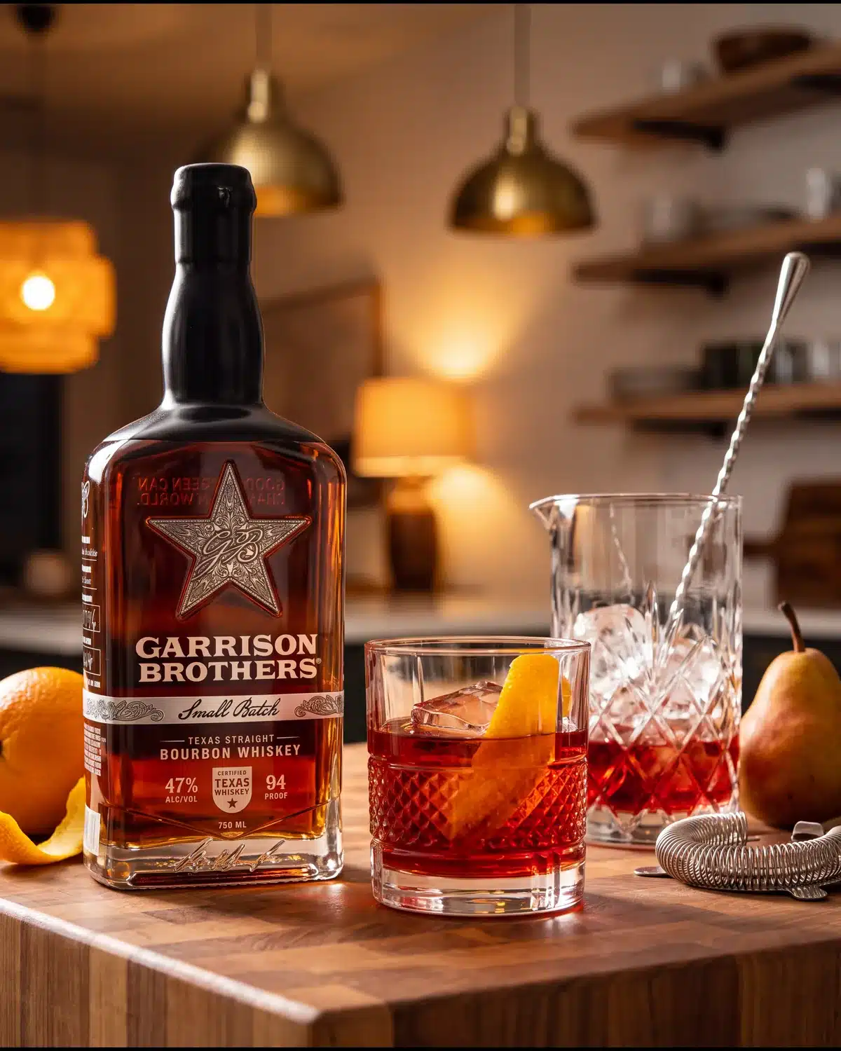 Brazos Boulevardier bourbon cocktail on a kitchen counter with a bottle of Garrison Brothers Small Batch Bourbon