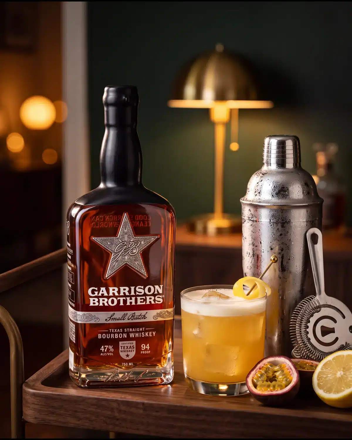 Lilikoi Cowboy bourbon cocktail on a home bar cart with a bottle of Garrison Brothers Small Batch Bourbon