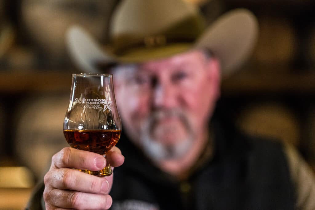 Dan Garrison holding a glencairn filled with bourbon whiskey