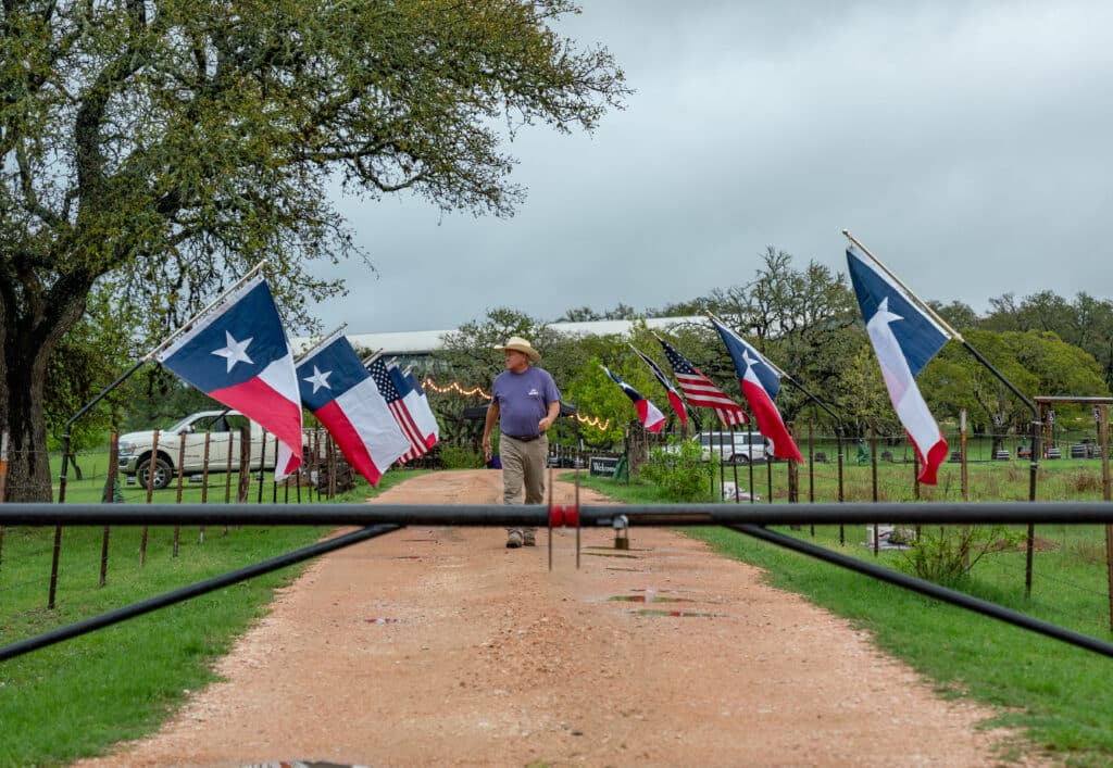 Dan Garrison walking to the entrance of the distillery lined with flags