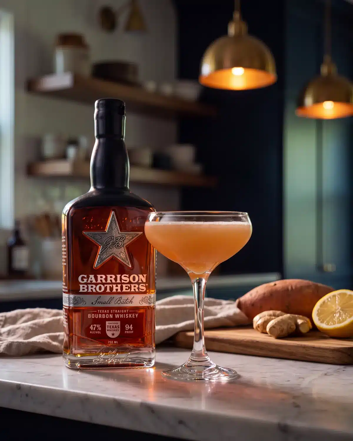 The Morning Glory bourbon cocktail on a kitchen counter with a bottle of Garrison Brothers Small Batch Bourbon