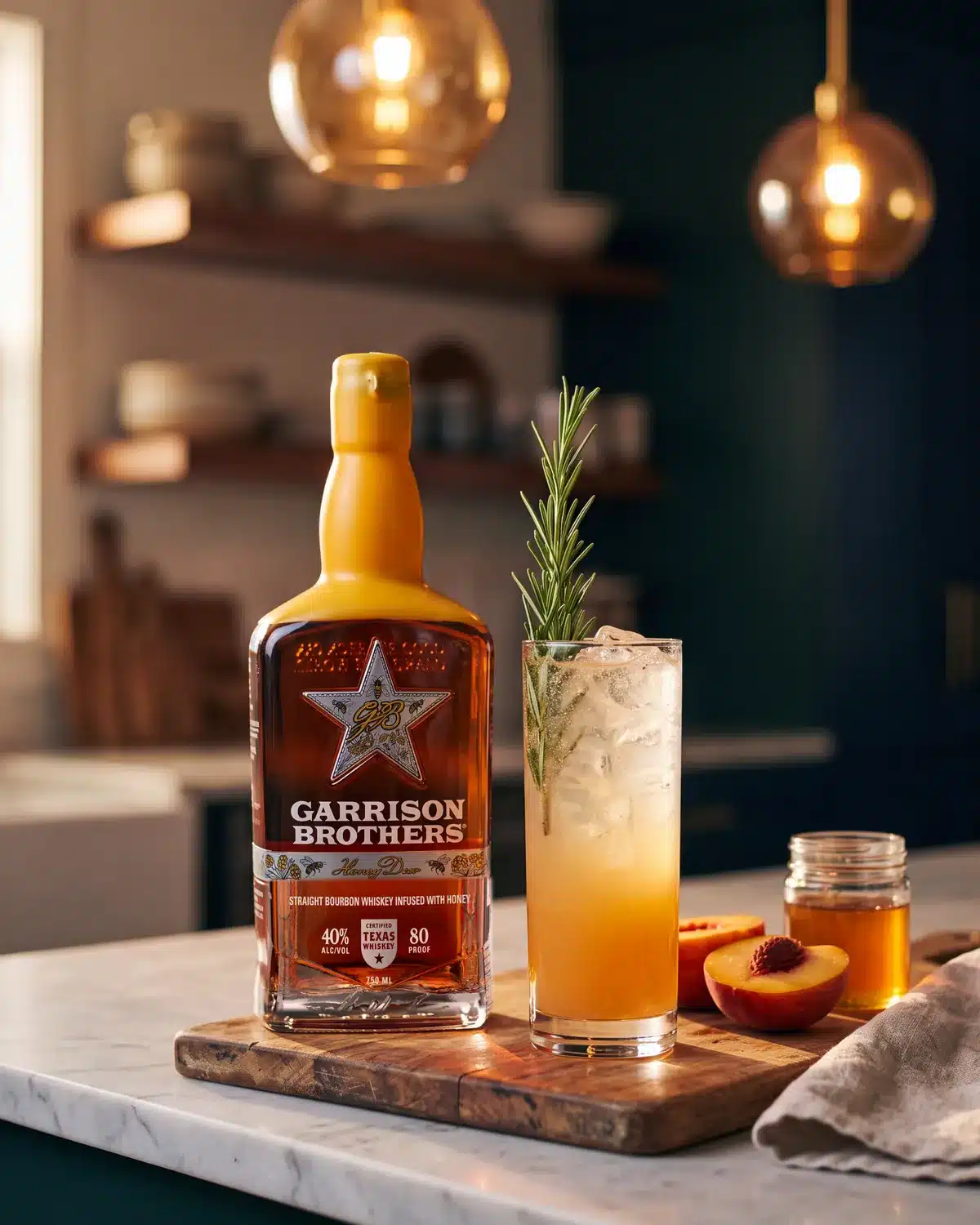 Smoking Gun bourbon cocktail on a kitchen counter with a bottle of Garrison Brothers HoneyDew Bourbon